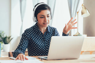 Femme écouteur sur les oreilles qui travaille à l'ordinateur