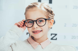 Une enfant met ses lunettes de vue