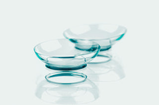 A pair of contact lenses sitting on a mirror