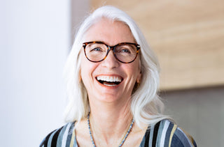 Une femme aux cheveux blancs qui portent des lunettes