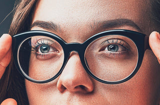 Une femme se met une paire de lunettes