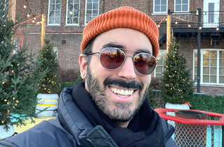 Alexandre Turcotte, ambassadeur d'IRIS, est dehors avec des lunettes de soleil, un manteau d'hiver et un tuque orange. 