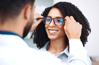 Un opticien ajuste une lunette sur une patiente