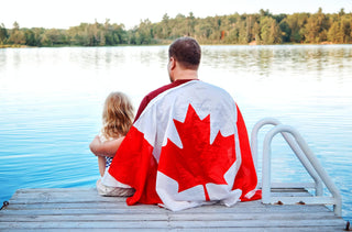 Un père et sa fille célèbre la fête du Canada sur le bord d'un lac