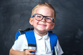 Un jeune garçon souriant avec des lunettes et un sac à dos