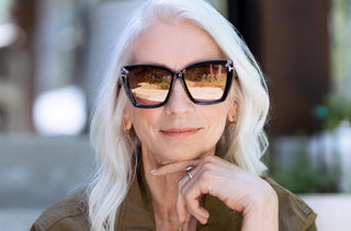 Femme aux cheveux blancs qui porte des lunettes solaires