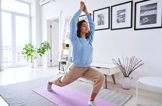 Une femme fait du yoga chez elle