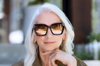 Une femme aux cheveux blancs qui porte des lunettes de soleil