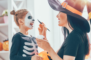 Une maman qui maquille sont enfant pour Halloween