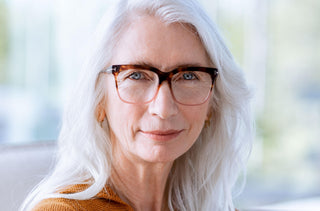 Femme avec les cheveux gris porte des lunettes