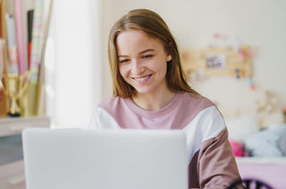 Jeune fille blonde qui travaille sur son portable