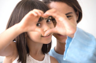 Une petite fille et sa mère joignent leur main pour former un coeur