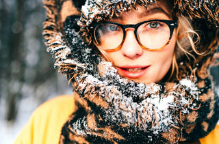 Gros plan d'une femme en manteau d'hiver. Ses lunettes sont un peu embuées