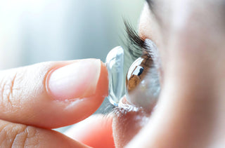 Une femme met ses lentilles cornéennes 