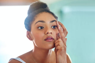 Une jeune femme noire mets ses lentilles cornéennes