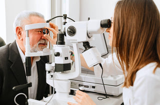 Une optométriste examine les yeux d'un vieil homme