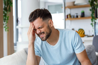 Un homme est en train d'avoir une migraine ophtalmique 