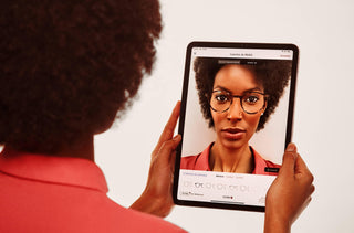 Une femme essaie des lunettes digitalement sur son iPad 