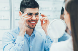 Homme qui essaie des lunettes face à un miroir 