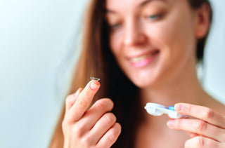 Gros plan sur une femme qui tiens une lentille cornéenne