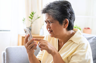 Une femme a de la difficulté à lire sur son téléphone