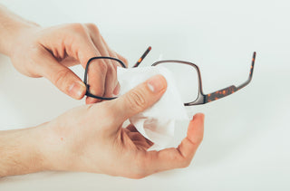 Une personne nettoie ses lunettes