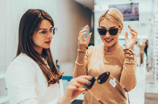 Une femme essaye une paire de lunettes de soleil