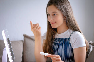 Une jeune fille mets des lentilles cornéennes