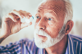 Un homme dans la soixantaine mets des goutes dans son oeil