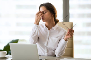 Une femme devant son ordinateur souffre de fatigue oculaire