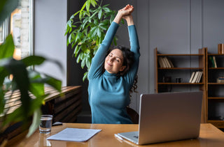 Une femme s'étire à son bureau