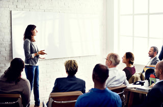 une femme donne une formation d'entreprise à un groupe de personnes