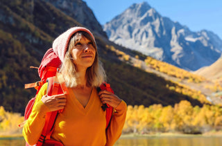 Portrait d'une femme en randonnée qui se tient devant un lac dans les montagnes automnales 