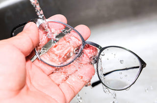 Une personne lave ses lunettes