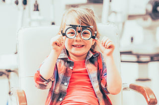 Un enfant porte un appareil optométrique sur les yeux en souriant.