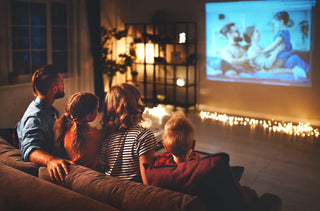 Une famille de 4 regarde un film sur un projecteur