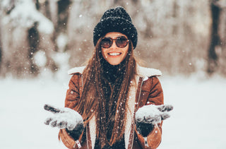 Une femme avec des lunettes de soleil en hiver