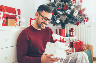 Un homme portant des lunettes reçoit un cadeau pour Noël