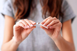 Une femme tient une cigarette brisée dans ses mains. 