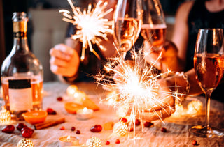 Des amis fêtent Noël ou du Nouvel An avec des lumières du Bengale et du champagne de rose.