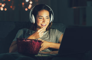 Une jeune femme qui écoute un film avec pop corn