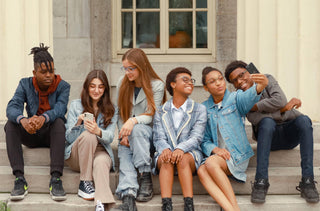 Un groupe d'adolescents est assis sur des marches d'escalier