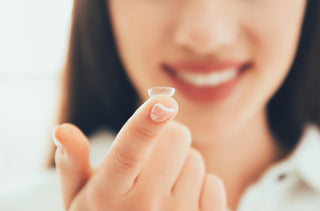 Femme avec une lentille cornéenne sur son doigts