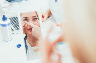 Une femme insère ses lentilles cornéennes