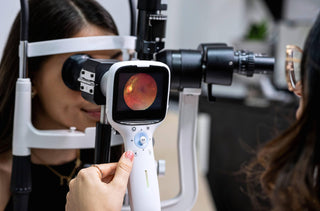 une optometriste effectue un examen de fond oculaire avec une caméra rétinienne.