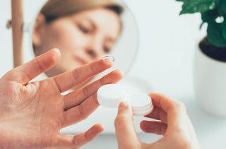 Une femme met ses lentilles cornéennes