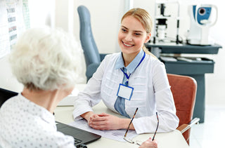 An older woman with white hair is speaking to her optometrist 