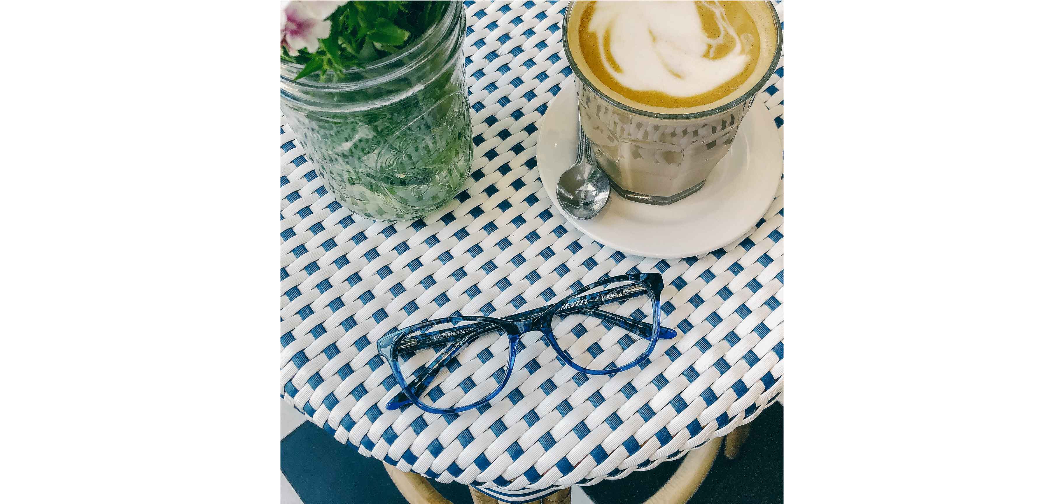 A pair of Steve Madden Knitted Blue on the table of a coffee shop beside a latte