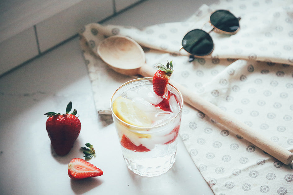 Glass of water with strawberries and lemon