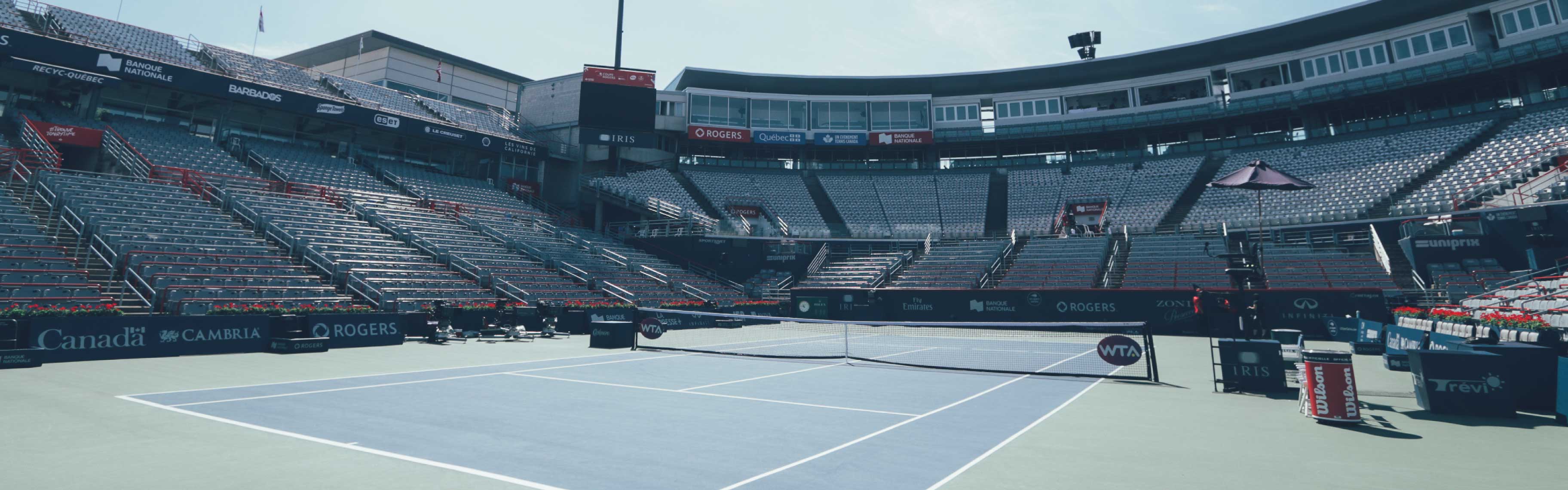 On voit le court central du Stade IGA à Montréal pendant la Coupe Rogers, des logos IRIS sont imprimés sur les parois et sous l'écran géant